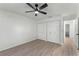 Bright bedroom showcases wood-look floors, ceiling fan, white walls, and double door closet at 1475 James St, New Smyrna Beach, FL 32168