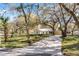 Charming single-story home with a long driveway and a yard landscaped with beautiful mature trees at 1475 James St, New Smyrna Beach, FL 32168