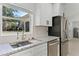 Close-up of a kitchen sink and granite countertops complimented by stainless steel appliances and white cabinets at 1475 James St, New Smyrna Beach, FL 32168