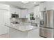 Bright and modern kitchen featuring stainless steel appliances, white cabinets, and an island with granite countertops at 1475 James St, New Smyrna Beach, FL 32168