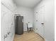 Functional laundry room features wood-look flooring, shelving, and a utility sink at 1475 James St, New Smyrna Beach, FL 32168