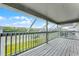 Large, screened-in porch or balcony with wooden floors, white railings, and views of the backyard at 219 Strathmore Cir, Kissimmee, FL 34744