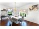 Elegant dining room with a modern chandelier, a white table, and views of the outdoors at 219 Strathmore Cir, Kissimmee, FL 34744