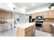 Well-lit kitchen featuring a center island, stainless steel appliances, and light wood cabinetry at 219 Strathmore Cir, Kissimmee, FL 34744
