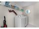 Convenient laundry room with appliances, shelving, decorative flowers, and a window for natural light at 219 Strathmore Cir, Kissimmee, FL 34744