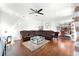 Spacious living room with hardwood floors, a sectional sofa, and a view into the dining and kitchen areas at 219 Strathmore Cir, Kissimmee, FL 34744