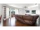 Comfortable living room with hardwood floors, leather sofa, and sliding doors to the outdoor pool area at 219 Strathmore Cir, Kissimmee, FL 34744