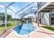 Backyard screened pool with a covered lanai, lounge seating, and a white picket fence at 219 Strathmore Cir, Kissimmee, FL 34744