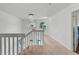 Upstairs hallway with carpet and a chandelier, leading to a bedroom with a large window at 219 Strathmore Cir, Kissimmee, FL 34744