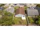Aerial view of the home featuring a well-maintained lawn, trees and a brown roof at 2218 Newt St, Orlando, FL 32837