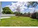 Nice backyard features a well-maintained lawn, mature trees and a white fence at 2218 Newt St, Orlando, FL 32837