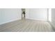 Spacious room with light hardwood floors, white trim, and an open doorway at 2218 Newt St, Orlando, FL 32837