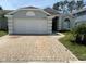 Charming single-story home with a well-manicured lawn and a brick driveway at 2218 Newt St, Orlando, FL 32837