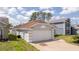 Side view of a well-maintained home featuring a spacious two-car garage and landscaped surroundings at 2218 Newt St, Orlando, FL 32837