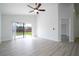 Open-concept living area with light wood floors, a sliding glass door to the backyard, and a ceiling fan at 2218 Newt St, Orlando, FL 32837