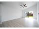 Bright living room featuring a ceiling fan, light wood floors, and a sliding door to the backyard at 2218 Newt St, Orlando, FL 32837