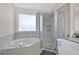 Bright bathroom features a soaking tub, glass-enclosed shower, and tiled walls at 2315 Anhinga Dr, Kissimmee, FL 34743