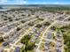 A birds-eye view reveals a well-planned residential community with neatly arranged houses, lush landscaping, and calm lake at 236 Elm Ct, Kissimmee, FL 34759