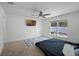 Neutral carpet in large bedroom with ceiling fan, window, and mounted TV at 236 Elm Ct, Kissimmee, FL 34759
