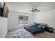 Neutral carpet and bright bedroom with ceiling fan, window, and mounted TV at 236 Elm Ct, Kissimmee, FL 34759