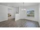 Bright dining area with wood-look floors, modern chandelier, and natural light at 236 Elm Ct, Kissimmee, FL 34759