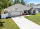 Well maintained single-story home with a long driveway and lush green lawn at 236 Elm Ct, Kissimmee, FL 34759