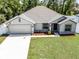 Well maintained single-story home with a long driveway and lush green lawn at 236 Elm Ct, Kissimmee, FL 34759