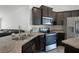 Modern kitchen features stainless steel appliances, dark cabinets, and stylish countertops at 236 Elm Ct, Kissimmee, FL 34759