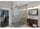 Bathroom featuring tile shower, wood vanity, decorative lighting, and walk-in closet at 243 Sagecrest Dr, Ocoee, FL 34761
