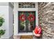 Elegant front door with decorative wreaths, stone accents, and a welcoming seating area at 243 Sagecrest Dr, Ocoee, FL 34761