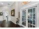 Inviting hallway with hardwood floors, white trim, and french doors leading to another room at 243 Sagecrest Dr, Ocoee, FL 34761