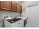 Functional laundry room with modern washer and dryer, upper cabinets, and a closed door at 243 Sagecrest Dr, Ocoee, FL 34761