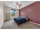 Cozy bedroom with large window, ceiling fan, and dark accent wall at 248 Wallrock Ct, Ocoee, FL 34761