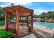 View of a wooden gazebo next to the community pool with trees and landscaping around it at 248 Wallrock Ct, Ocoee, FL 34761