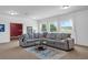 Cozy living room with carpeting, gray sectional sofa, and lots of natural light at 248 Wallrock Ct, Ocoee, FL 34761