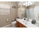 Bright bathroom featuring a single sink vanity, toilet, and tub with tiled shower and coastal decor at 2509 Archfeld Blvd, Kissimmee, FL 34746