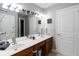 Bathroom featuring double sinks with granite countertop, tiled floors and modern fixtures at 2509 Archfeld Blvd, Kissimmee, FL 34746