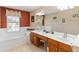 Bright bathroom with double sinks and a tub under a window lets in plenty of natural light at 2509 Archfeld Blvd, Kissimmee, FL 34746