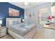 Stylishly decorated bedroom with a blue accent wall, floral artwork, and a comfortable bed at 2509 Archfeld Blvd, Kissimmee, FL 34746