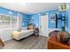 Playful bedroom with a single bed, creative wall design, and wood plank floors at 2509 Archfeld Blvd, Kissimmee, FL 34746