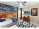 The bedroom has twin beds, creative murals and a space themed ceiling fan, for a unique and inspiring atmosphere at 2509 Archfeld Blvd, Kissimmee, FL 34746
