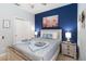 Bedroom featuring blue accent wall, white furniture, a queen bed, and ample natural light at 2509 Archfeld Blvd, Kissimmee, FL 34746