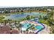 Aerial view of a large community pool and waterslides with palm trees and lounge chairs, perfect for relaxation at 2509 Archfeld Blvd, Kissimmee, FL 34746