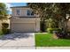 Charming two-story home features a well-maintained lawn and an attached two-car garage at 2509 Archfeld Blvd, Kissimmee, FL 34746
