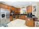 Well-lit kitchen featuring stainless steel appliances, warm wood cabinetry, and black granite countertops at 2509 Archfeld Blvd, Kissimmee, FL 34746