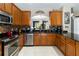 Bright kitchen featuring stainless steel appliances, mosaic backsplash, wood cabinets, and black granite countertops at 2509 Archfeld Blvd, Kissimmee, FL 34746