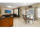 Open-concept living area features a large TV, comfortable seating, and a dining table with backyard access at 2509 Archfeld Blvd, Kissimmee, FL 34746