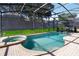 Screened in pool and spa with brick patio and lush landscaping at 2509 Archfeld Blvd, Kissimmee, FL 34746