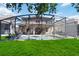 Large screened pool and patio area with lush lawn in backyard at 2509 Archfeld Blvd, Kissimmee, FL 34746