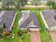 Aerial view of a house with solar panels, a brick driveway, and lush greenery surrounding the property at 254 Andalusia Loop, Davenport, FL 33837